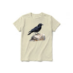 Un T-shirt latte à manches courtes et col rond pour jeune, orné d'un motif représentant un oiseau sur le devant.